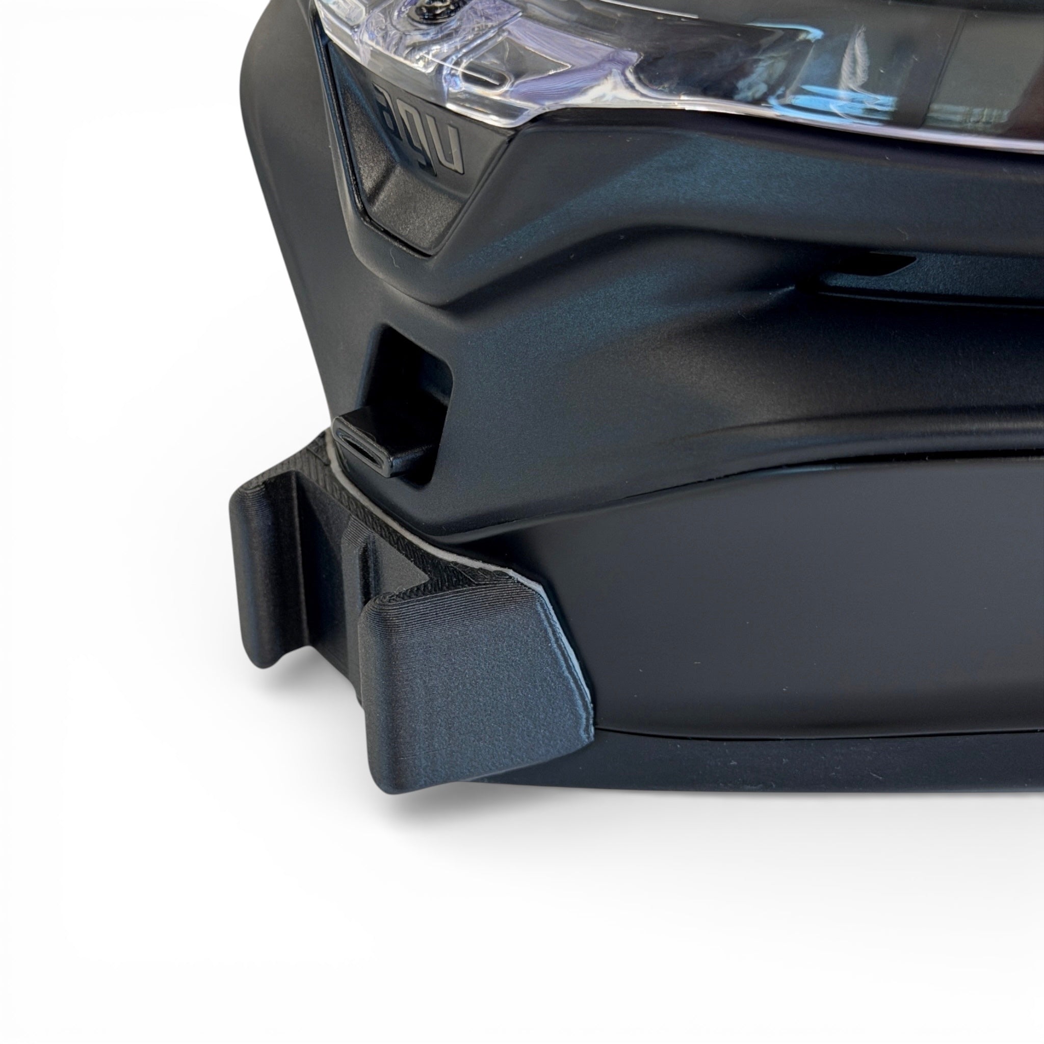 Primer plano del soporte de mentonera RiderMounts en la barbilla del casco AGV K7