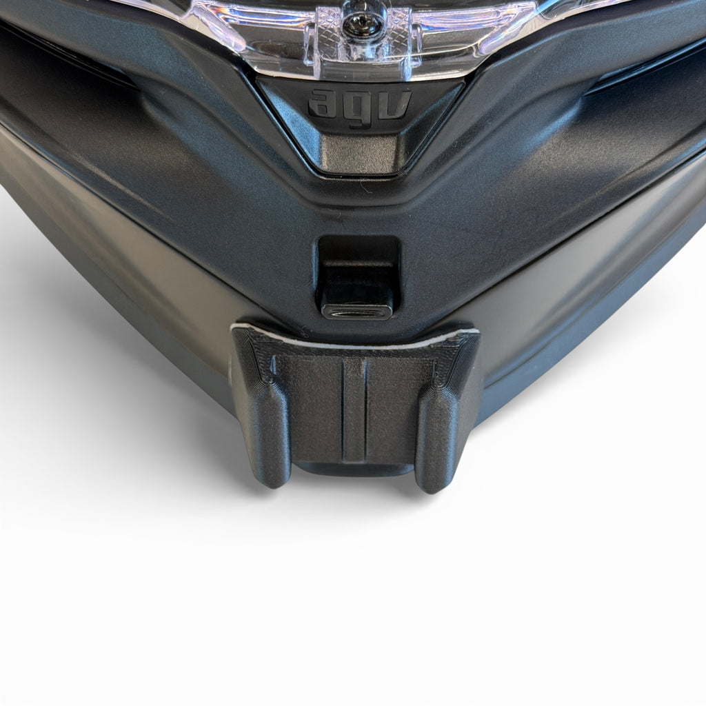 Vista frontal del casco AGV K7 con el soporte de mentonera RiderMounts montado