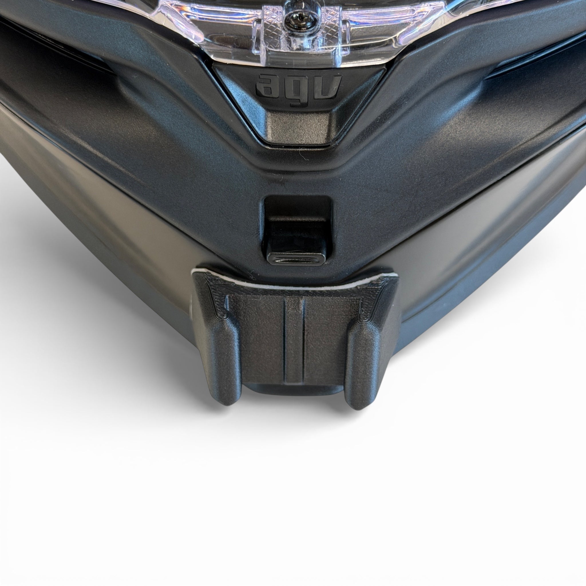 Vista frontal del casco AGV K7 con el soporte de mentonera RiderMounts montado