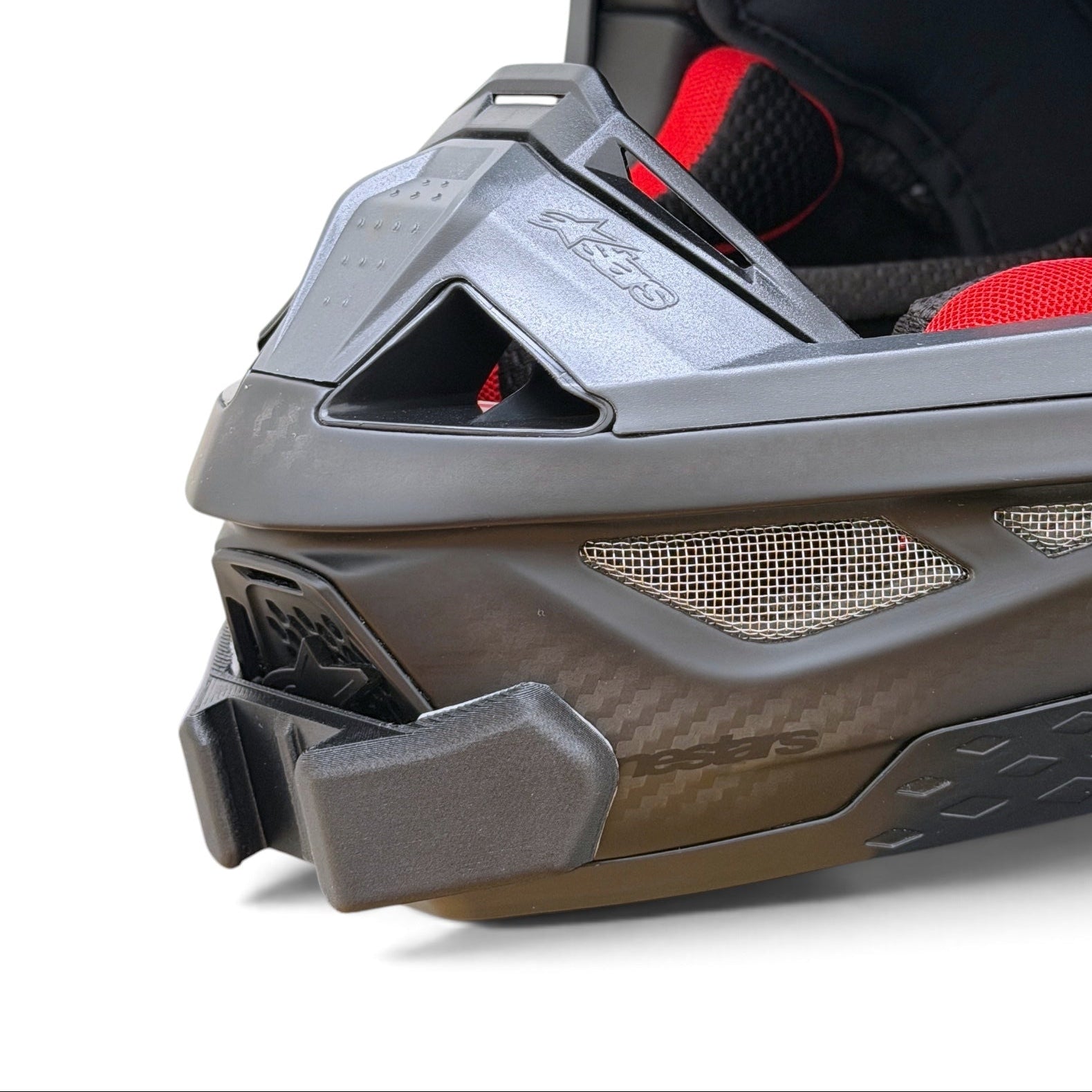 Primer plano del soporte de mentonera RiderMounts en la barbilla del casco ALPINESTARS SUPERTECH M10