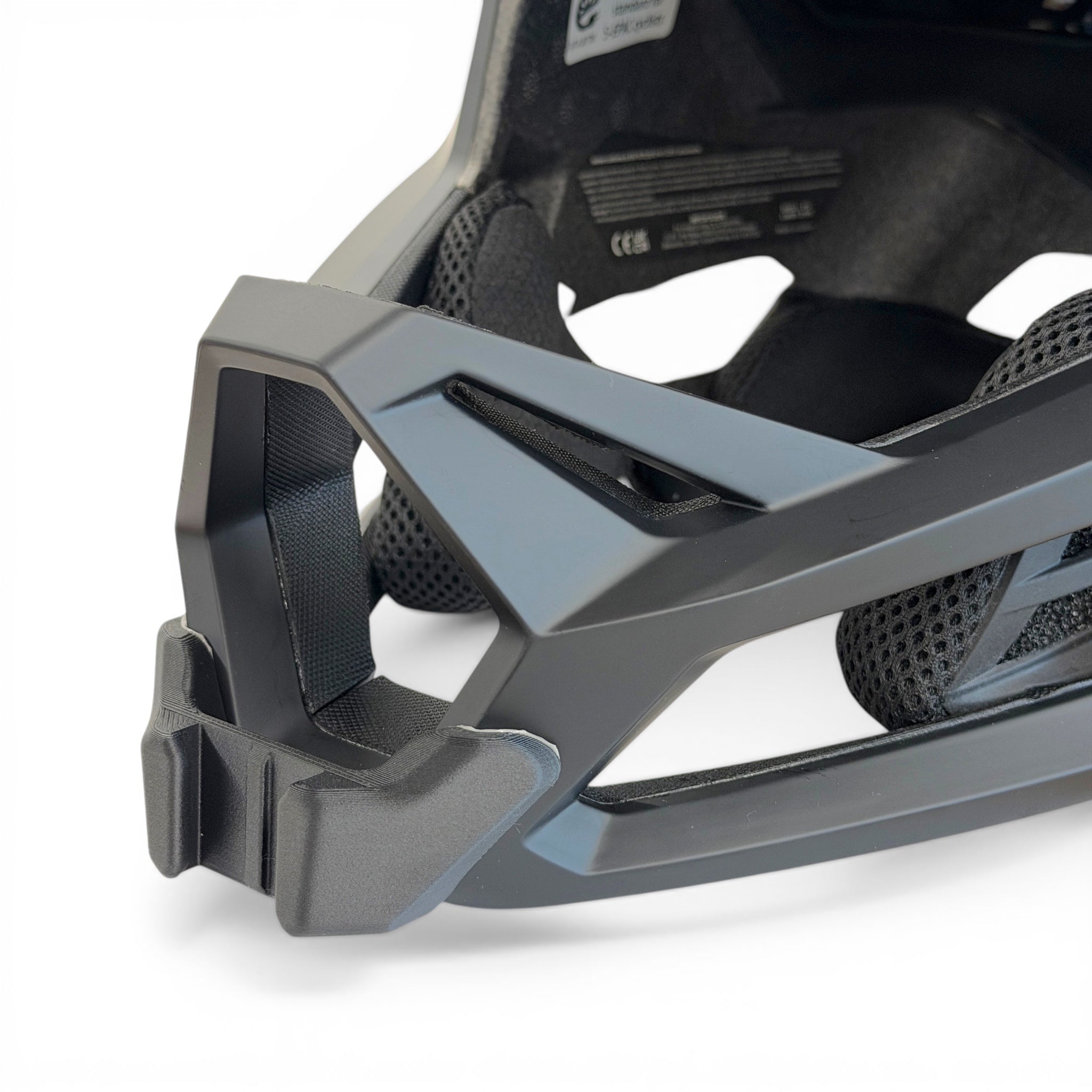 Primer plano del soporte de mentonera RiderMounts en la barbilla del casco FOX PROFRAME RS