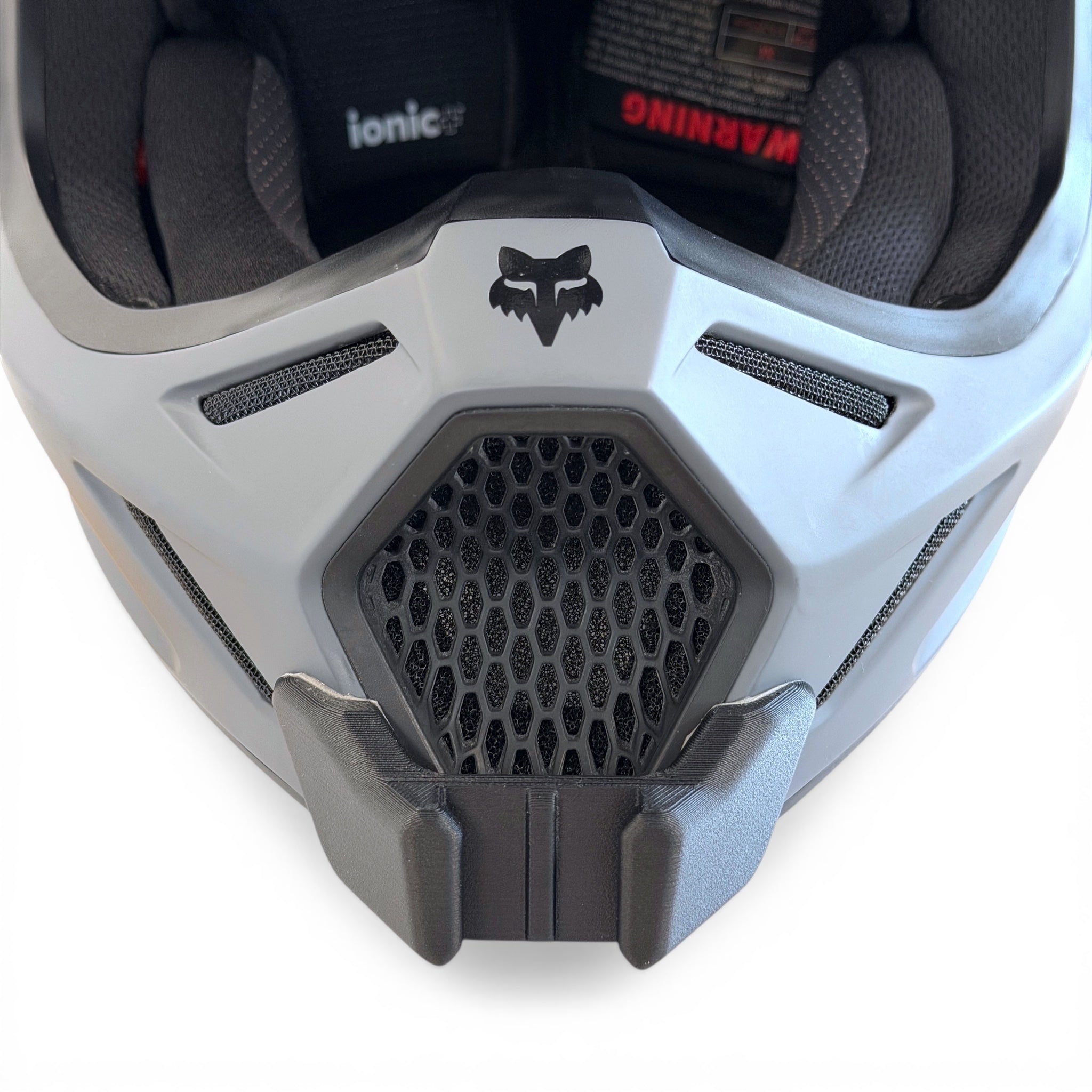 Vista frontal del casco FOX V3 con el soporte de mentonera RiderMounts montado
