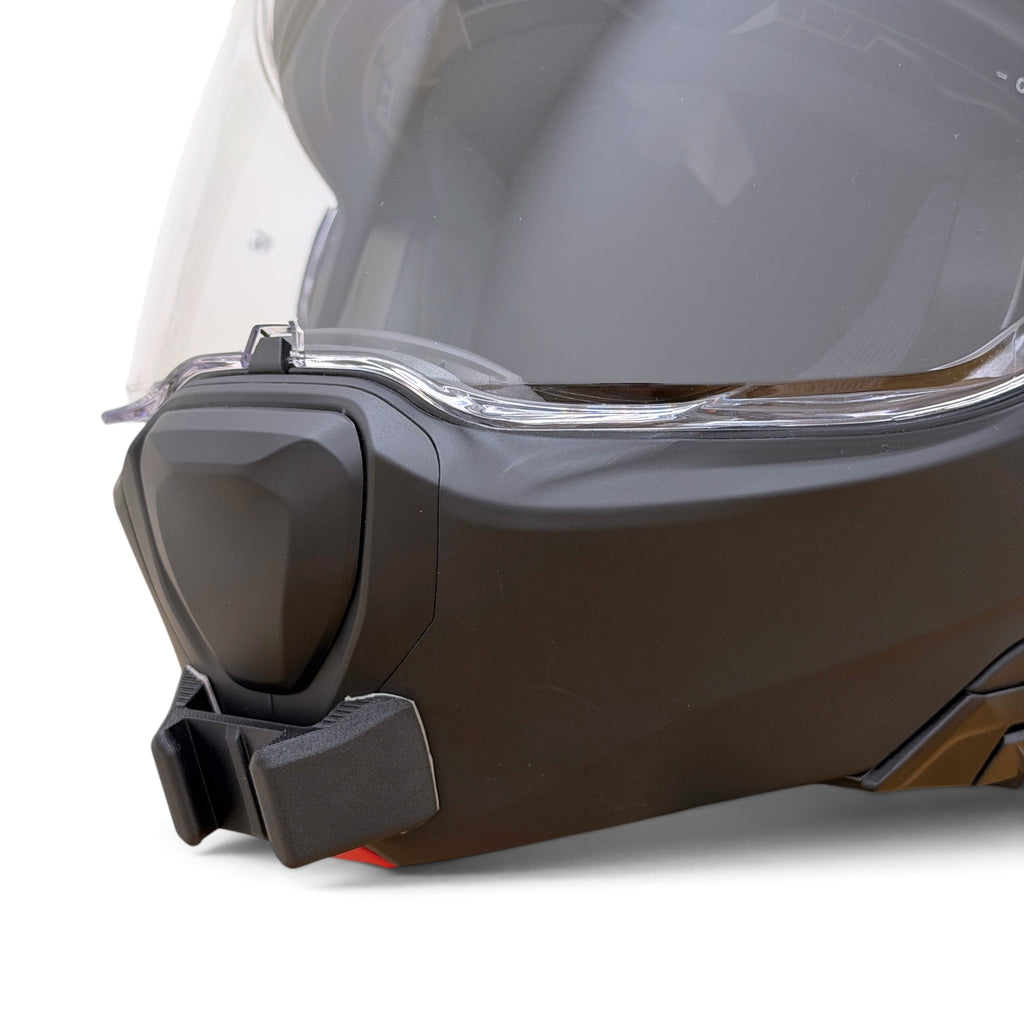 Primer plano del soporte de mentonera RiderMounts en la barbilla del casco HJC F100