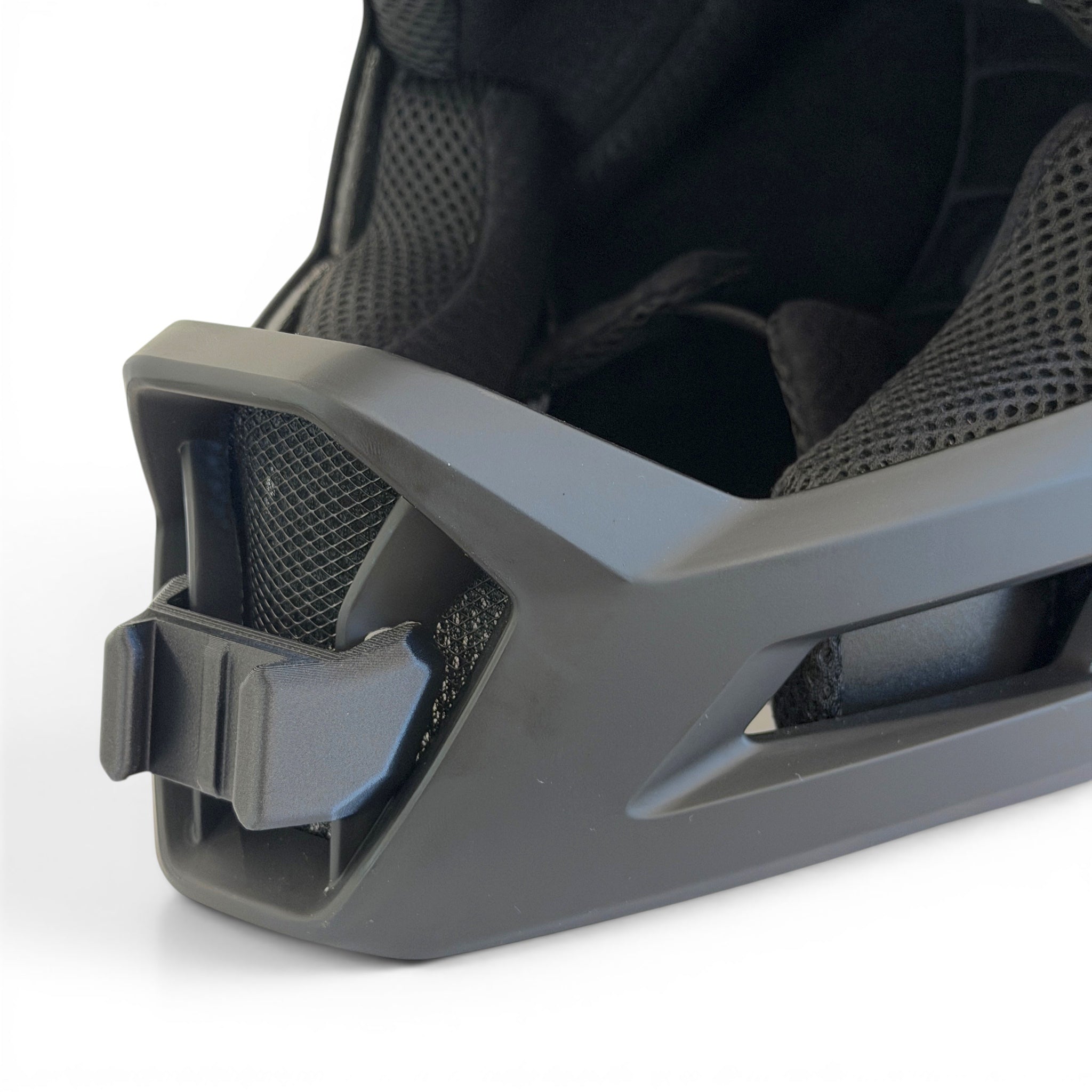 Primer plano del soporte de mentonera RiderMounts en la barbilla del casco LEATT GRAVITY 1.0