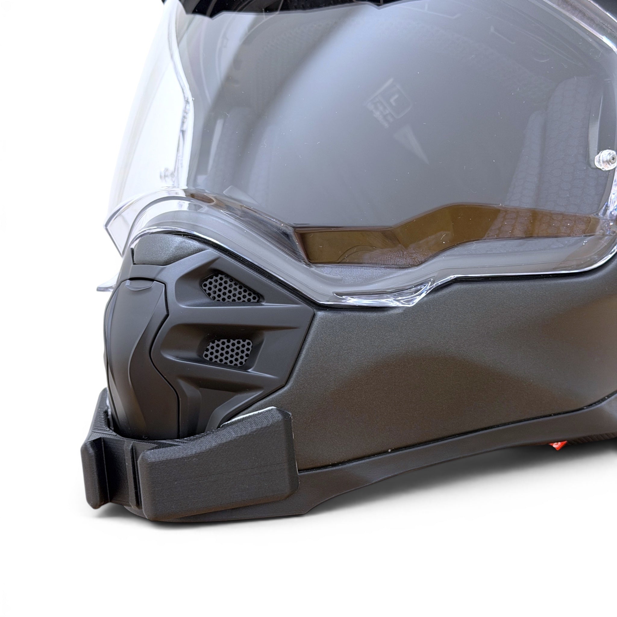 Primer plano del soporte de mentonera RiderMounts en la barbilla del casco SCORPION ADF-9000 AIR SOLID